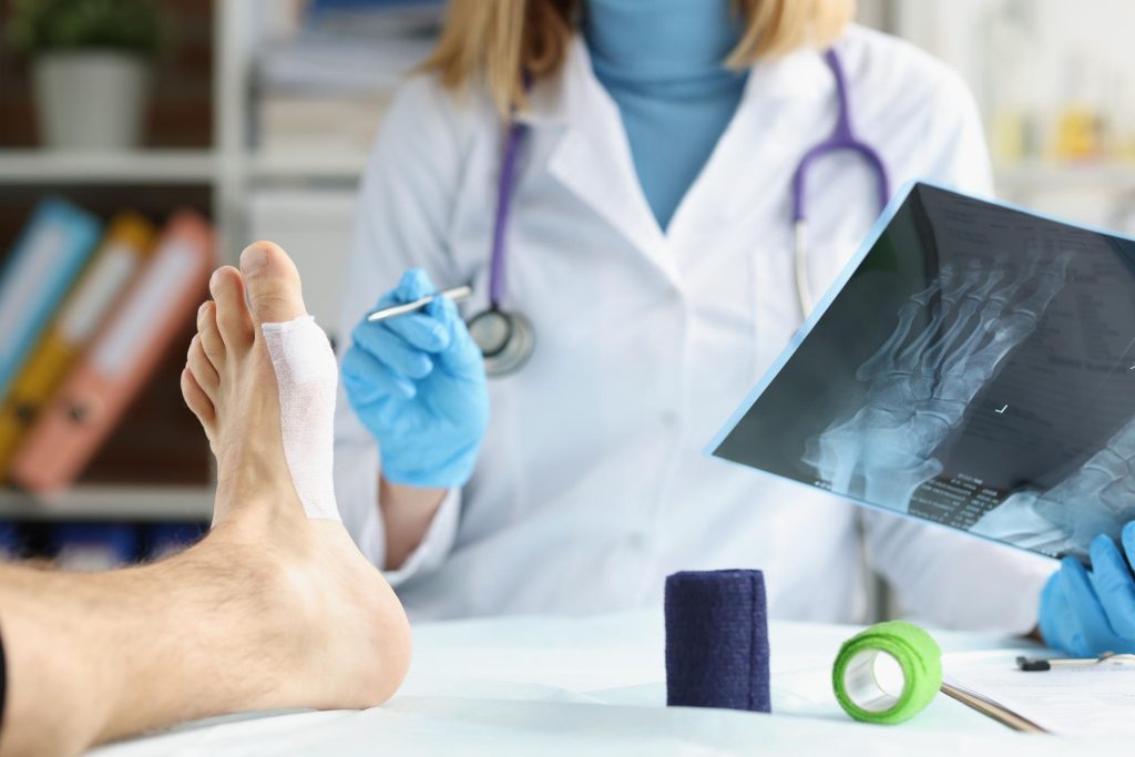 El médico revisa la radiografía de las piernas del paciente con consulta médica y tratamiento de lesiones
